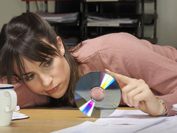 young-female-office-worker-slumped-at-desk-toying-with-cd-38